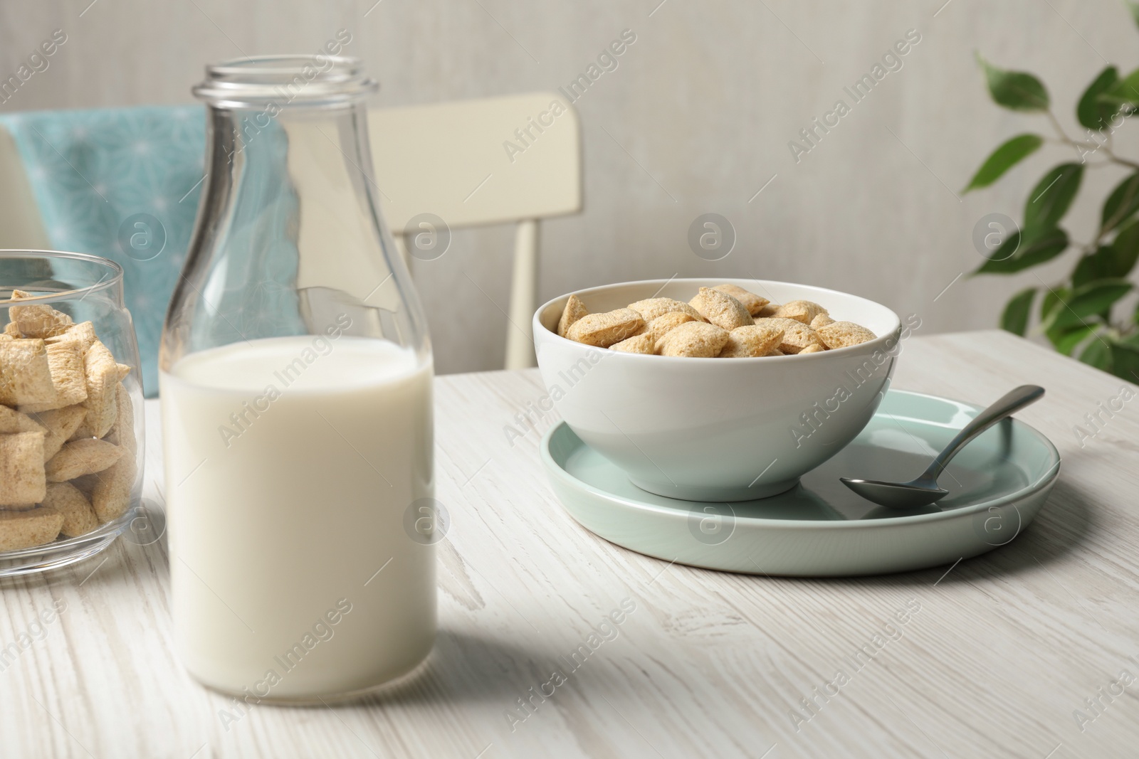 Photo of Tasty corn pads with milk served for breakfast on white wooden table in kitchen