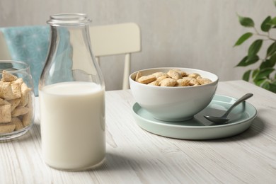 Tasty corn pads with milk served for breakfast on white wooden table in kitchen