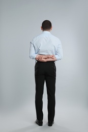 Photo of Professional businessman on grey background, back view