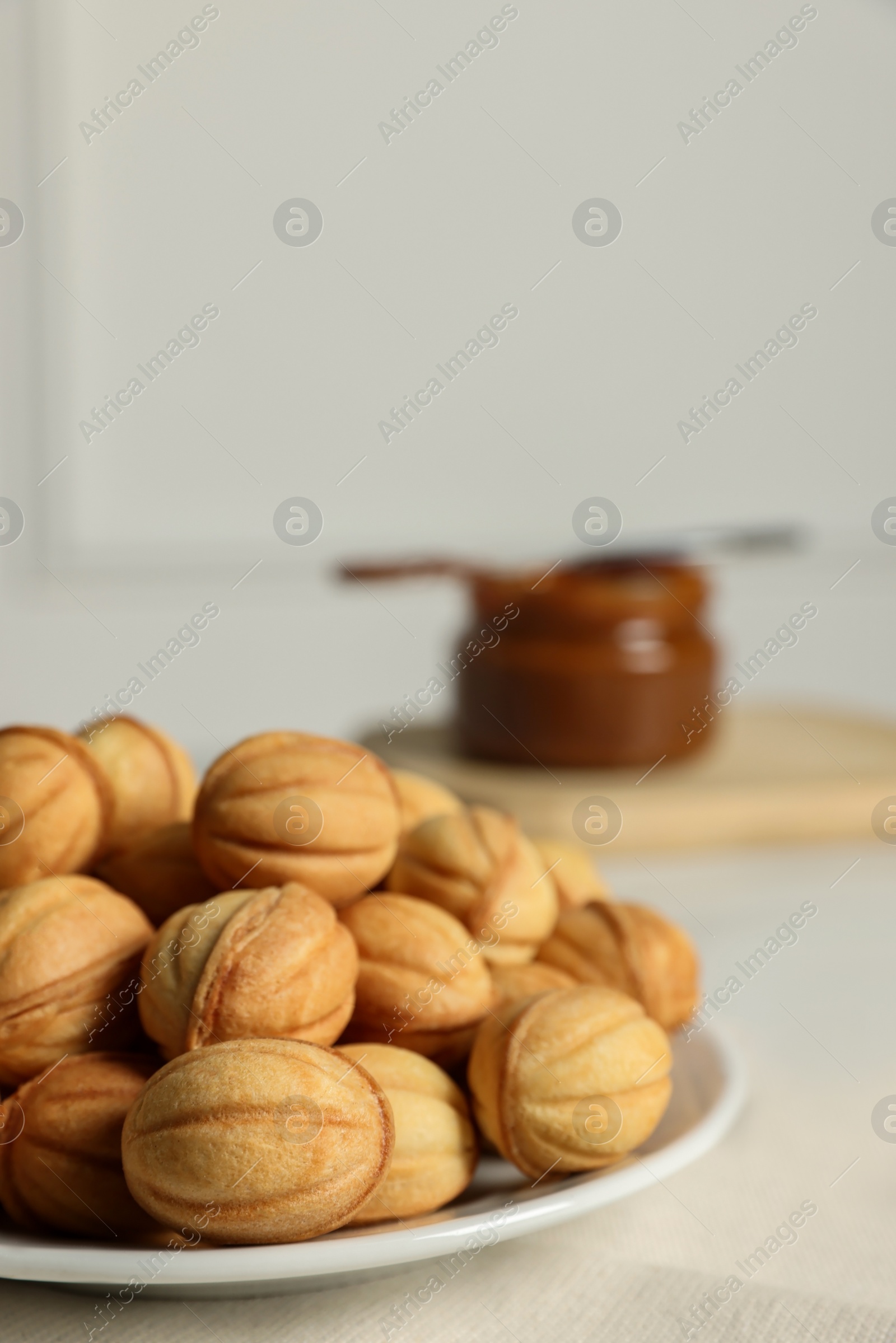 Photo of Homemade walnut shaped cookies with boiled condensed milk on table, space for text