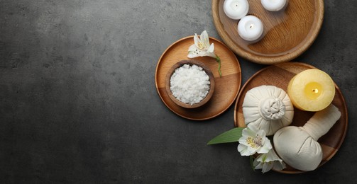 Photo of Flat lay composition with different spa products and lily flowers on grey table. Space for text