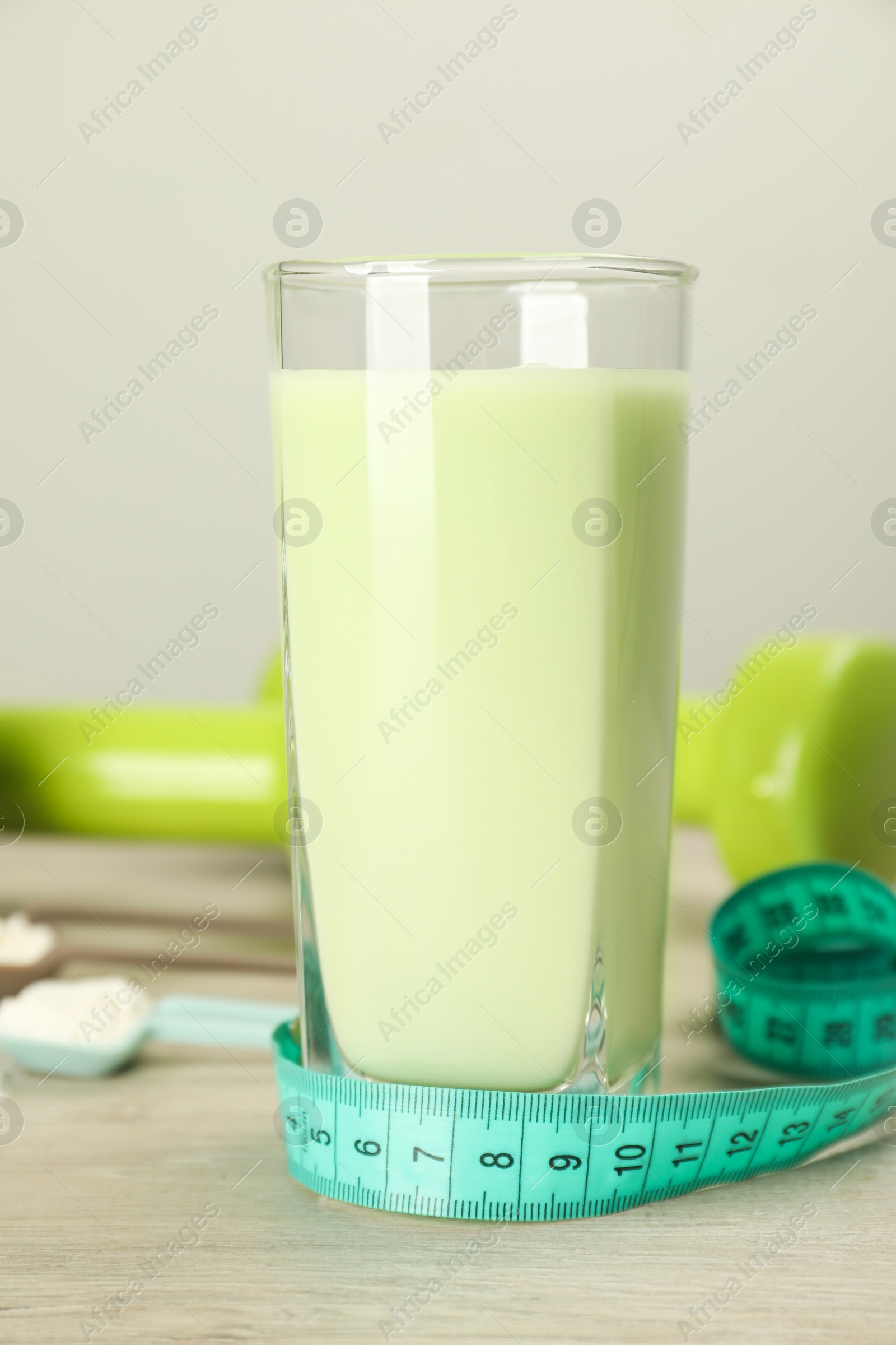 Photo of Tasty shake and measuring tape on wooden table. Weight loss