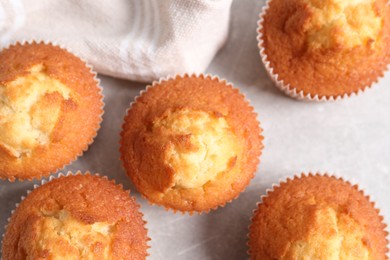 Tasty muffins on light grey table, flat lay. Fresh pastry