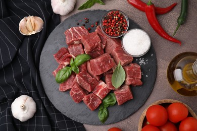 Flat lay composition with cut fresh beef meat on brown table