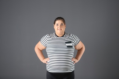 Portrait of overweight woman on gray background