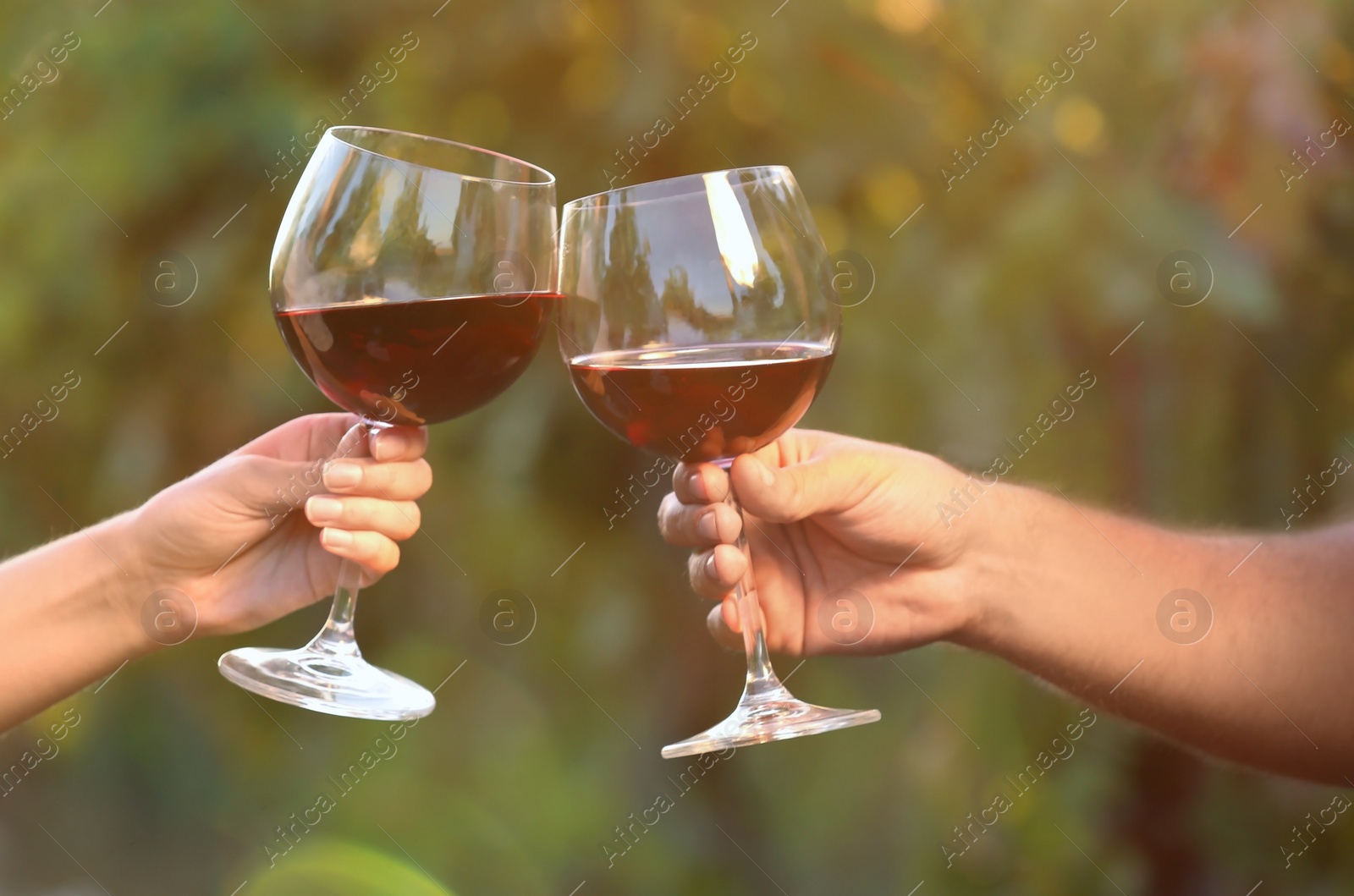 Photo of Couple with glasses of red wine outdoors, closeup