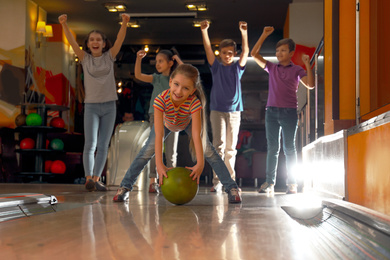 Photo of Girl throwing ball and spending time with friends in bowling club