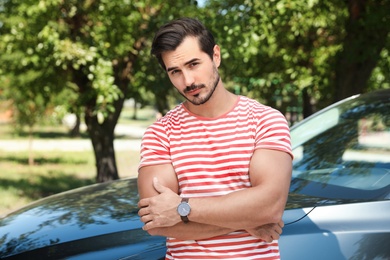 Photo of Attractive young man near luxury car outdoors