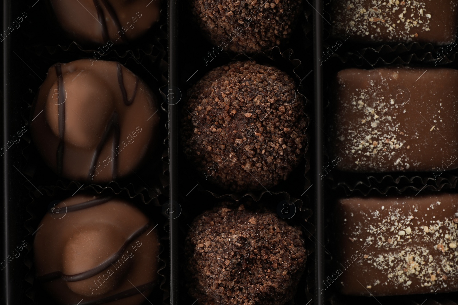 Photo of Many different chocolate candies in box, closeup