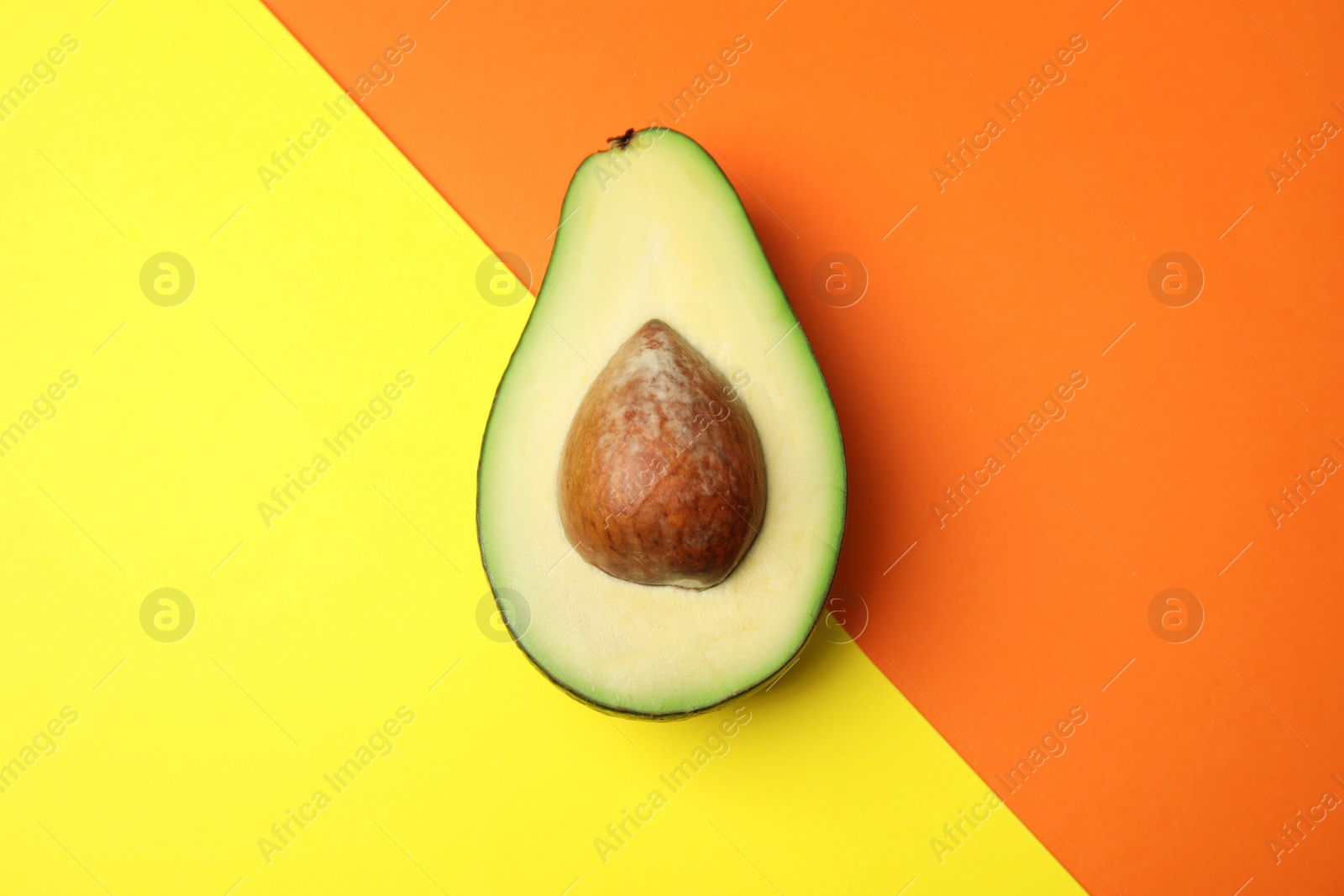 Photo of Cut fresh ripe avocado on color background, top view