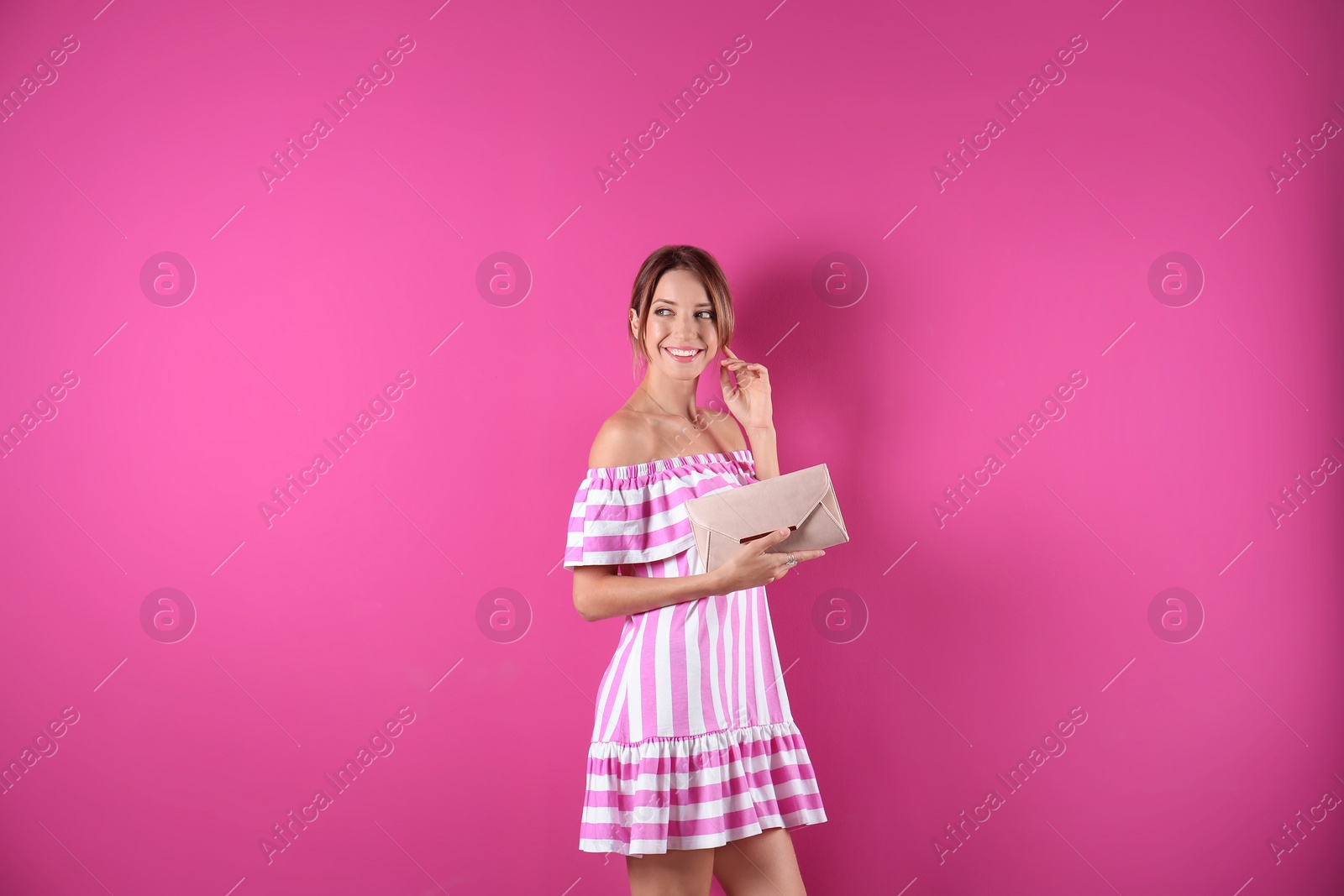 Photo of Portrait of young woman in stylish outfit with purse on color background