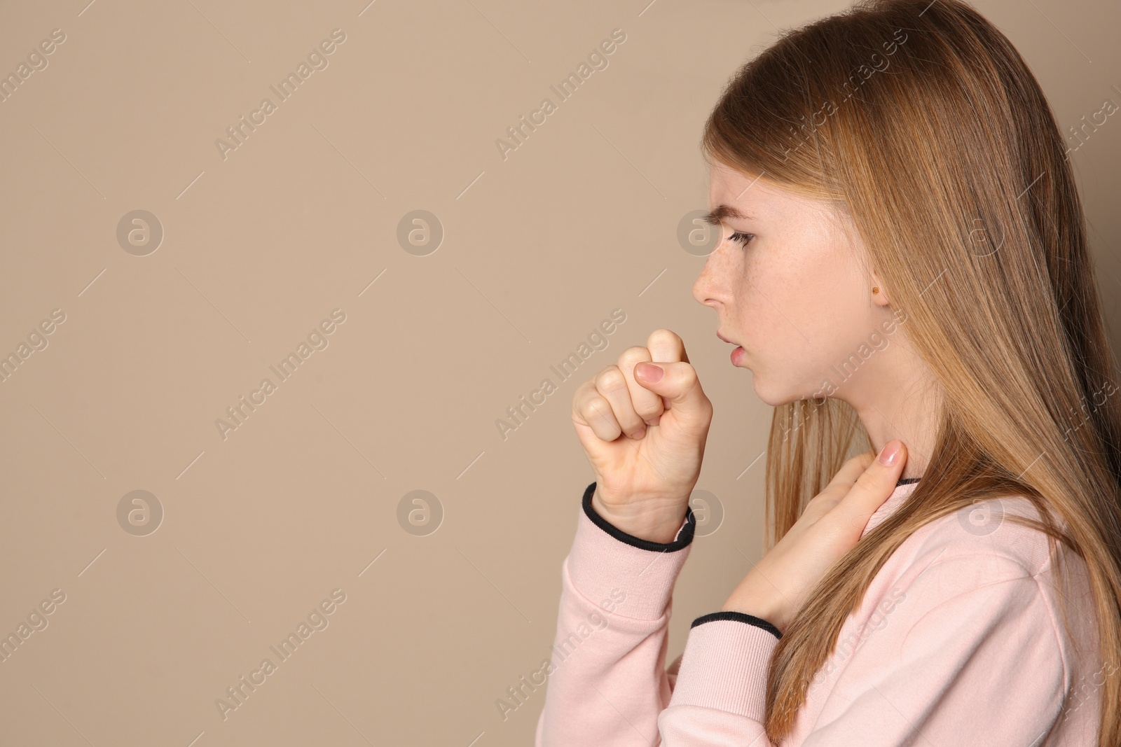 Photo of Teenage girl suffering from cough on color background. Space for text