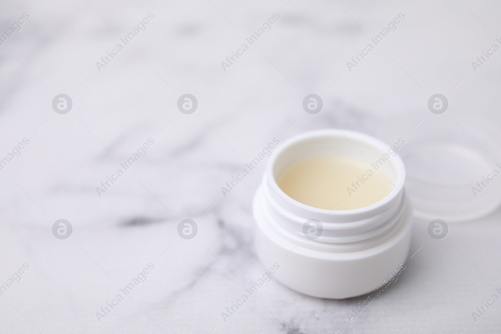 Photo of Jar of petroleum jelly on light background, space for text