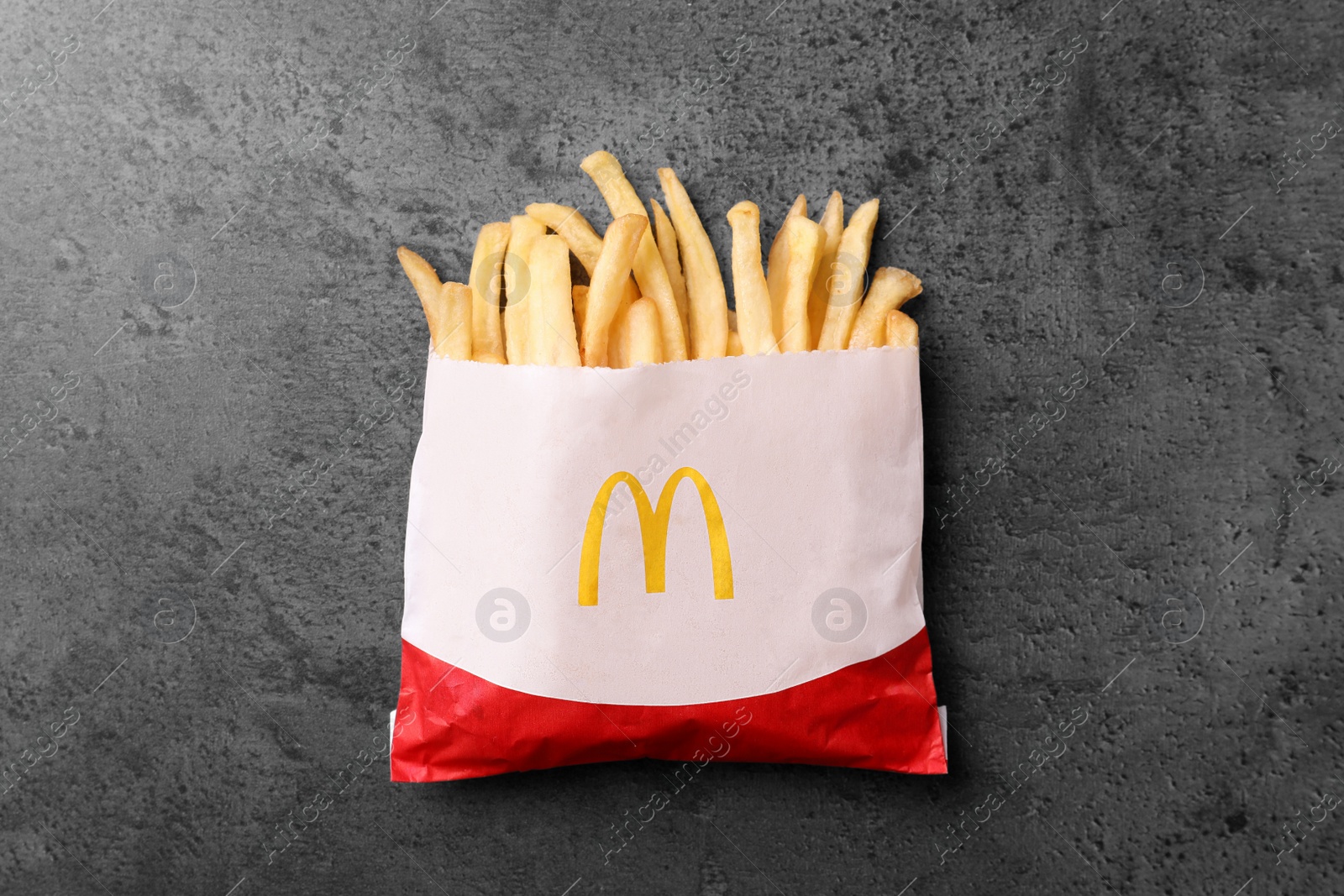 Photo of MYKOLAIV, UKRAINE - AUGUST 12, 2021: Small portion of McDonald's French fries on grey table, top view