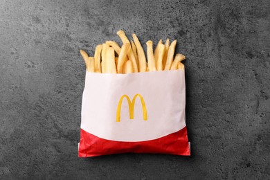 Photo of MYKOLAIV, UKRAINE - AUGUST 12, 2021: Small portion of McDonald's French fries on grey table, top view