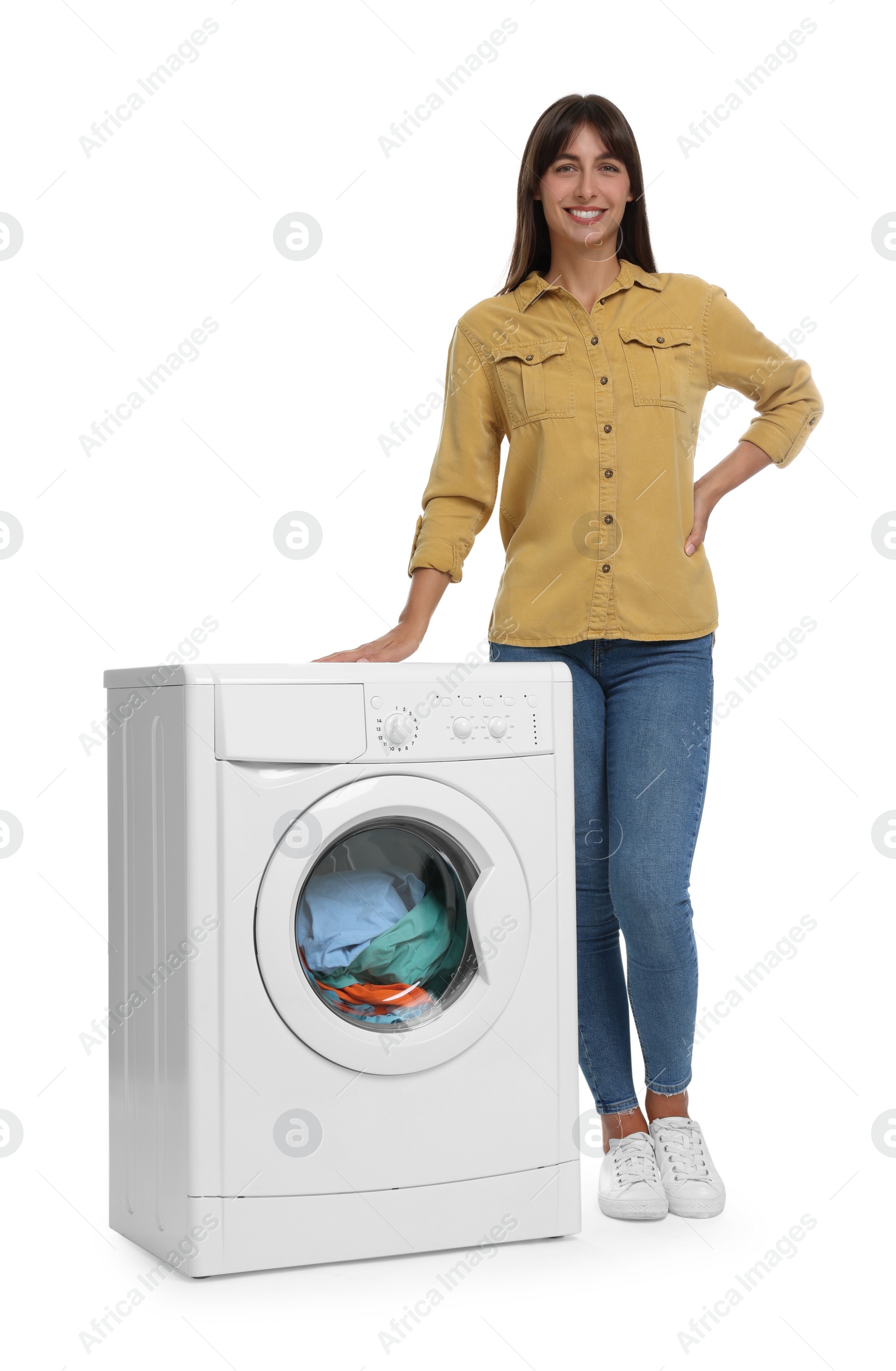 Photo of Beautiful woman near washing machine with laundry on white background