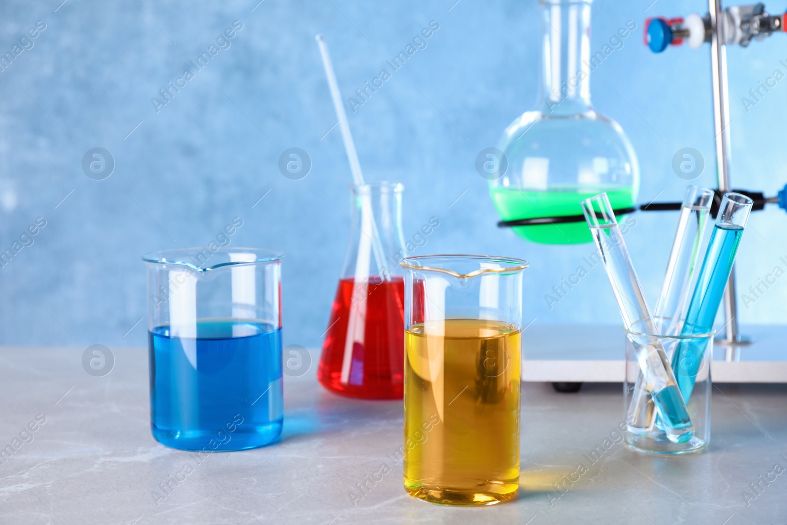 Photo of Different glassware with samples on table in chemistry laboratory