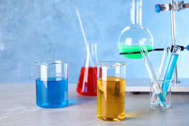 Photo of Different glassware with samples on table in chemistry laboratory