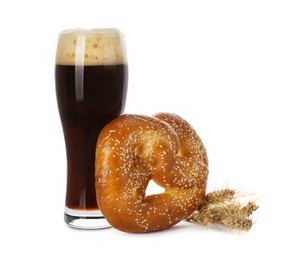 Photo of Tasty freshly baked pretzel, glass of dark beer and spikelets on white background