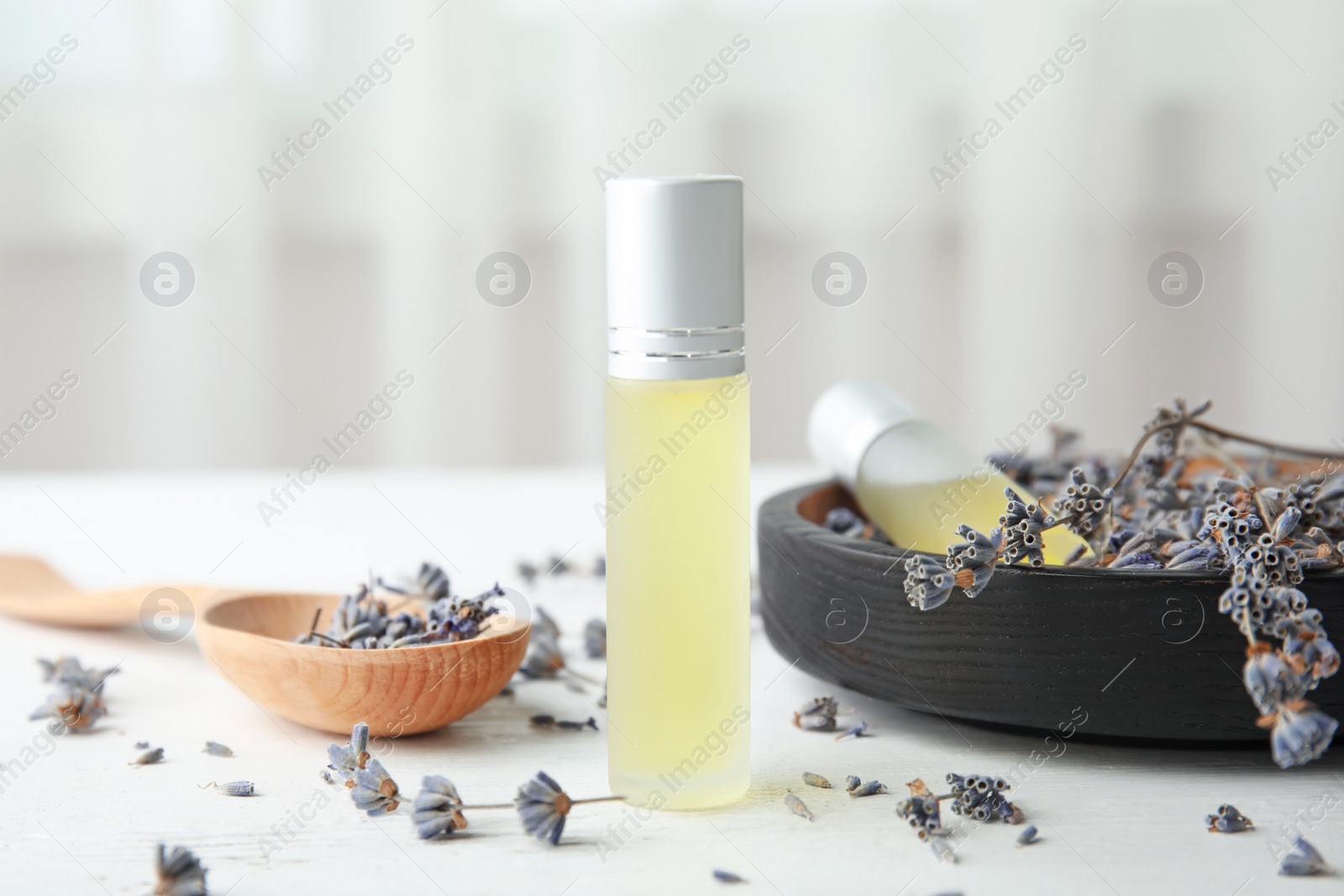 Photo of Composition with essential oil and flowers on table