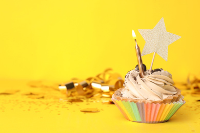 Photo of Birthday cupcake with candle on yellow background, space for text