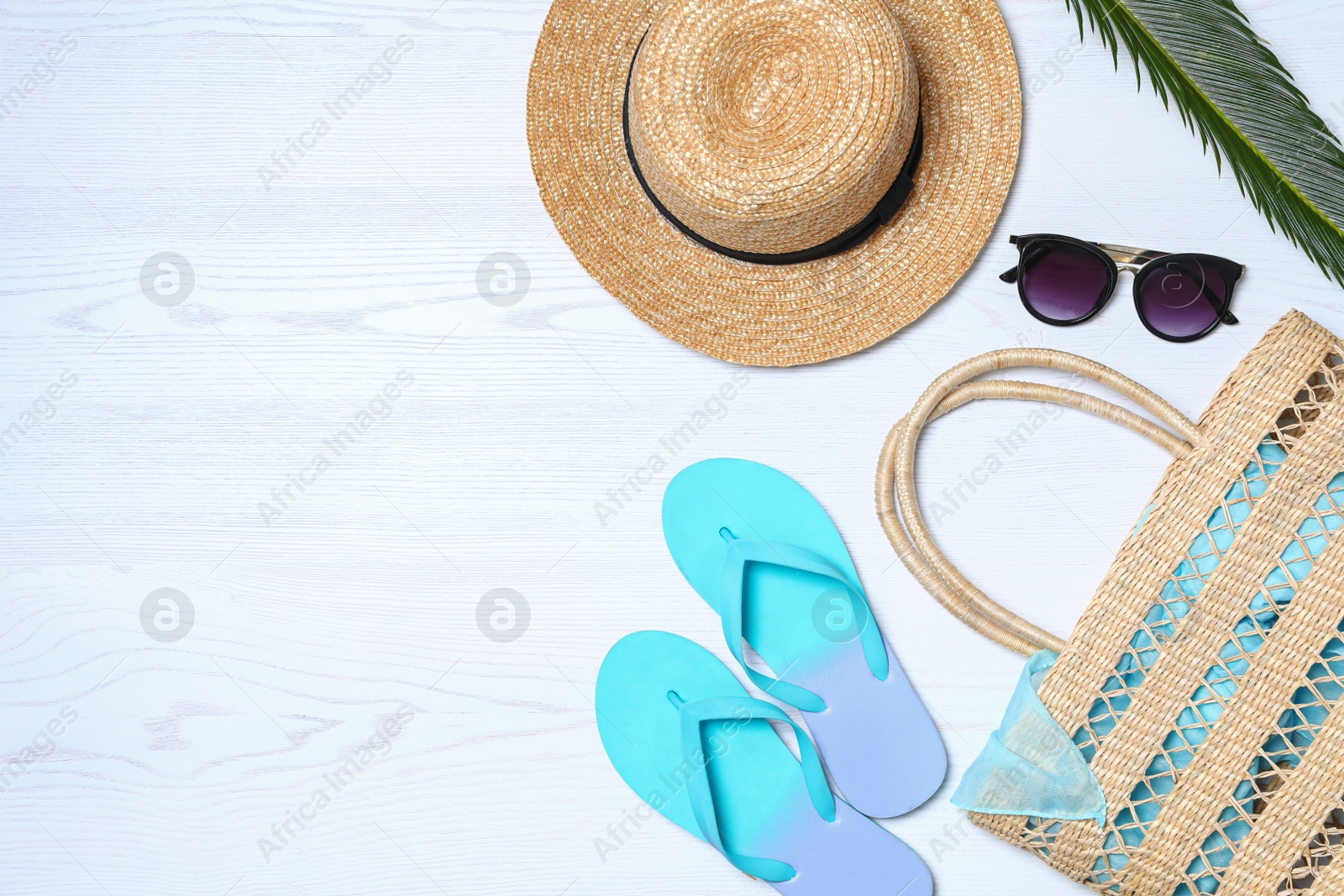 Photo of Flat lay composition with beach bag and accessories on white wooden background, space for text