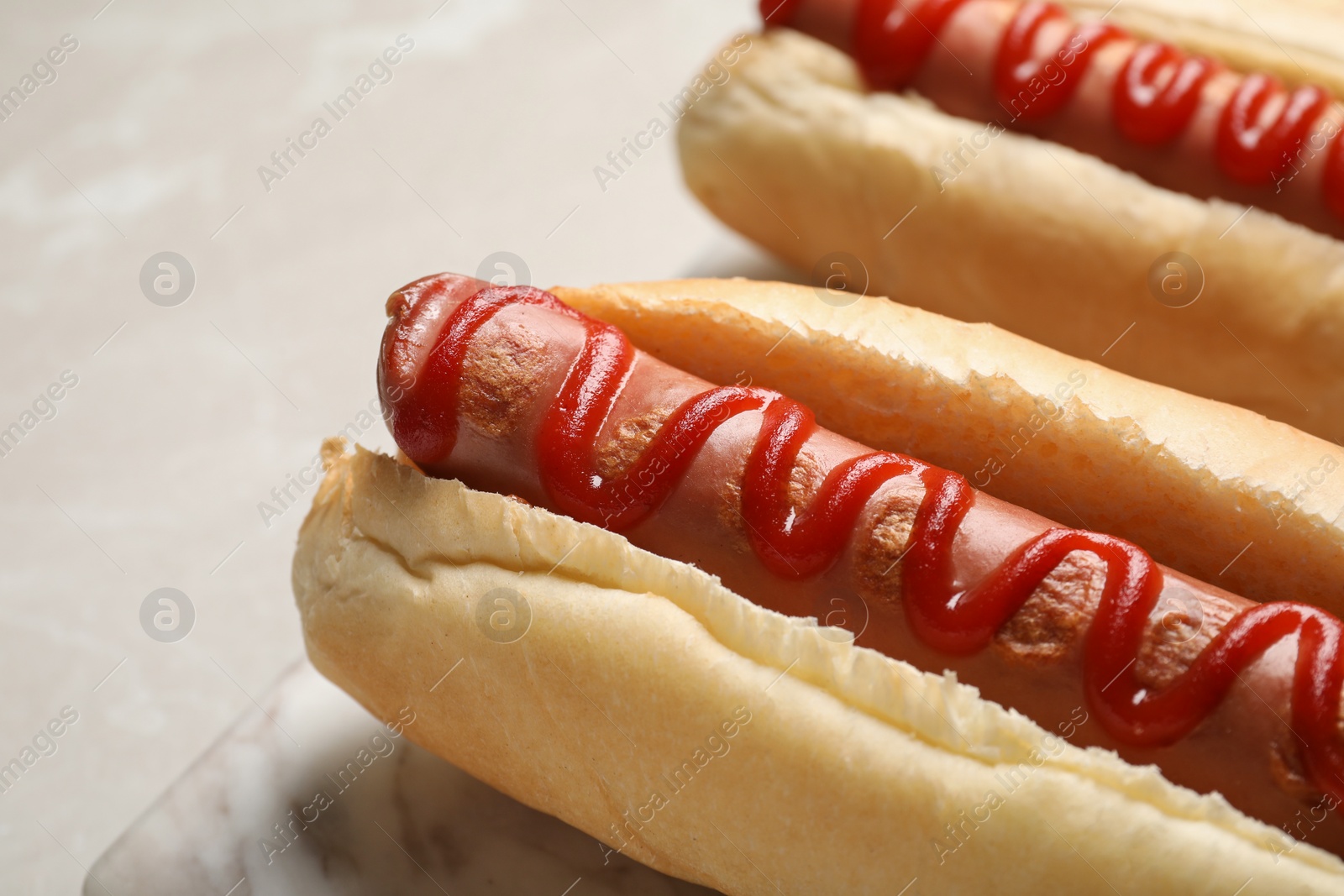 Photo of Fresh delicious hot dogs with ketchup on table, closeup