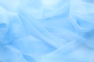 Photo of Beautiful light blue tulle fabric as background, top view