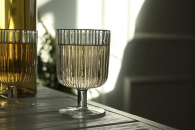 Alcohol drink in glasses on wooden table indoors, closeup. Space for text