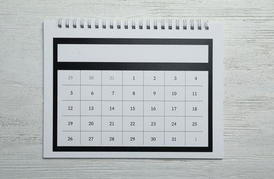 Paper calendar on white wooden background, top view