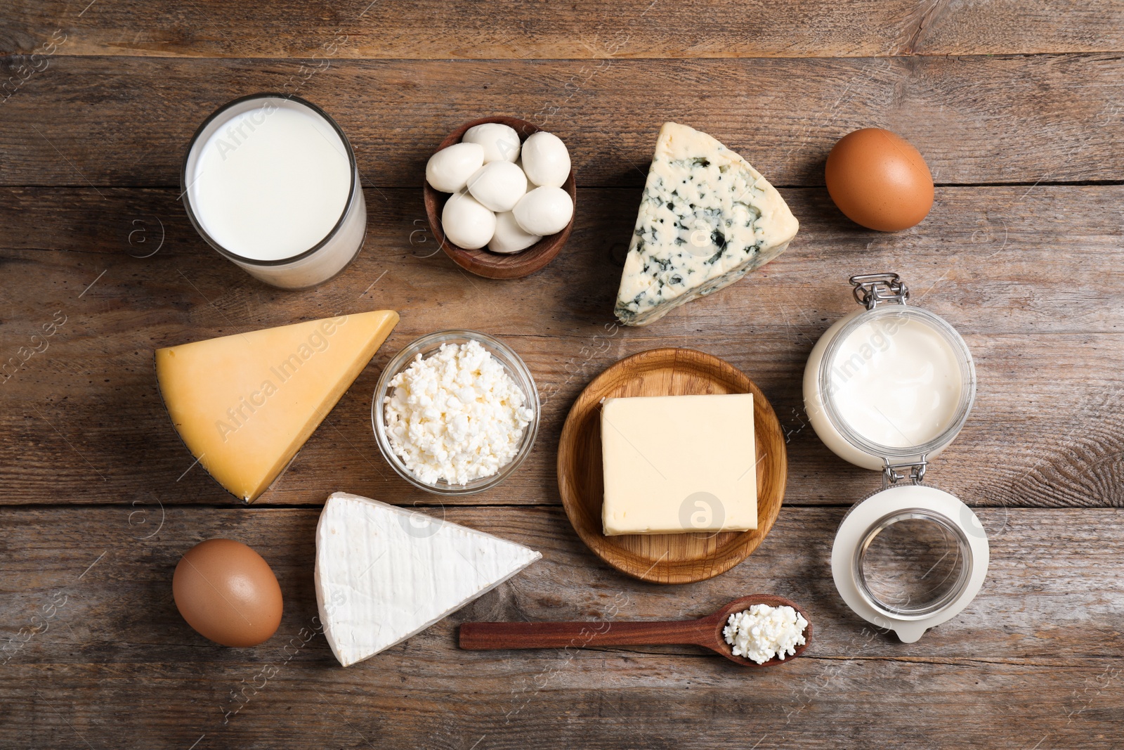 Photo of Different dairy products on wooden table, flat lay