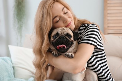 Woman with cute pug dog at home. Animal adoption