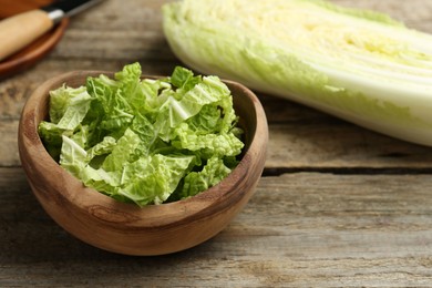 Photo of Cut fresh Chinese cabbage on wooden table, closeup