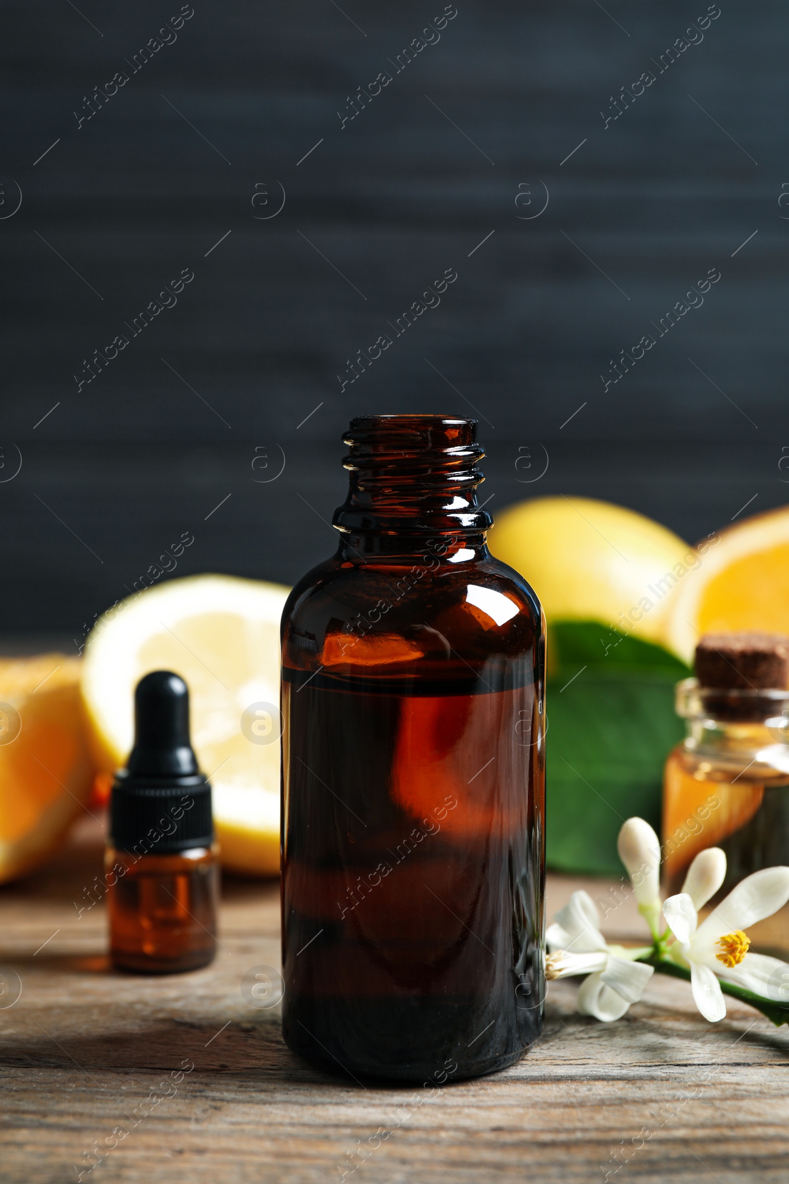 Photo of Bottles of citrus essential oil on wooden table