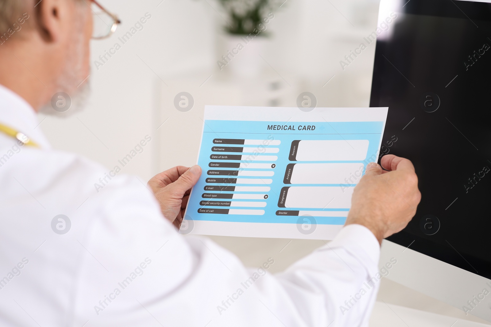 Photo of Doctor with patient's medical card in clinic, closeup