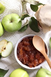 Photo of Bowl of delicious apple jam and fresh fruits on white tablecloth, flat lay