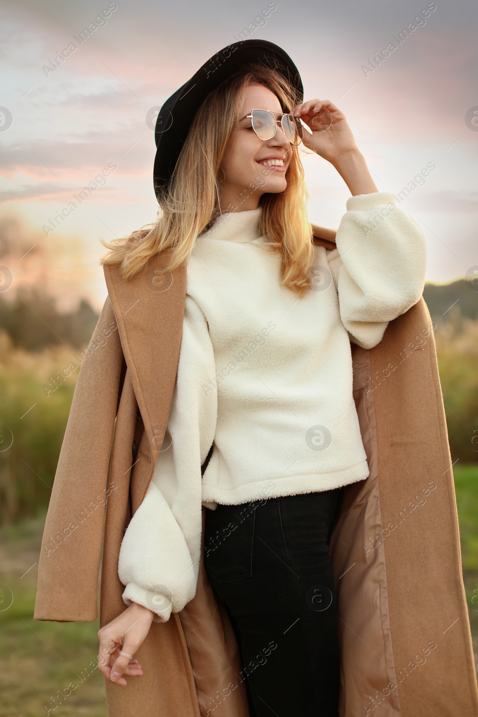 Photo of Beautiful young woman wearing stylish autumn clothes outdoors