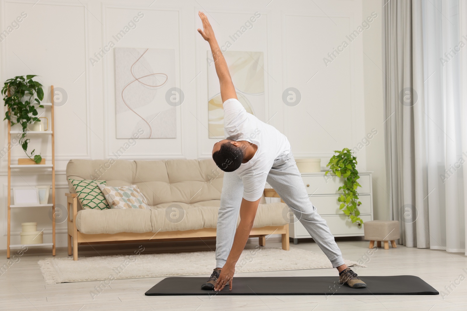 Photo of Man doing morning exercise on fitness mat at home