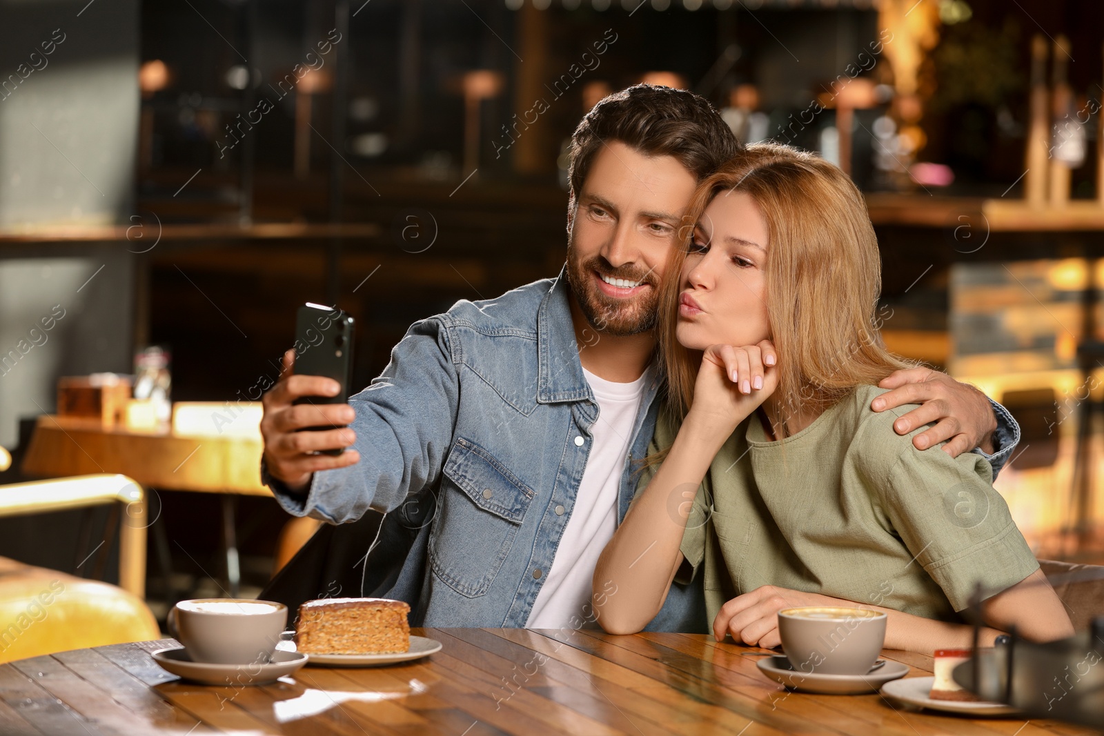 Photo of Romantic date. Happy couple taking selfie in cafe