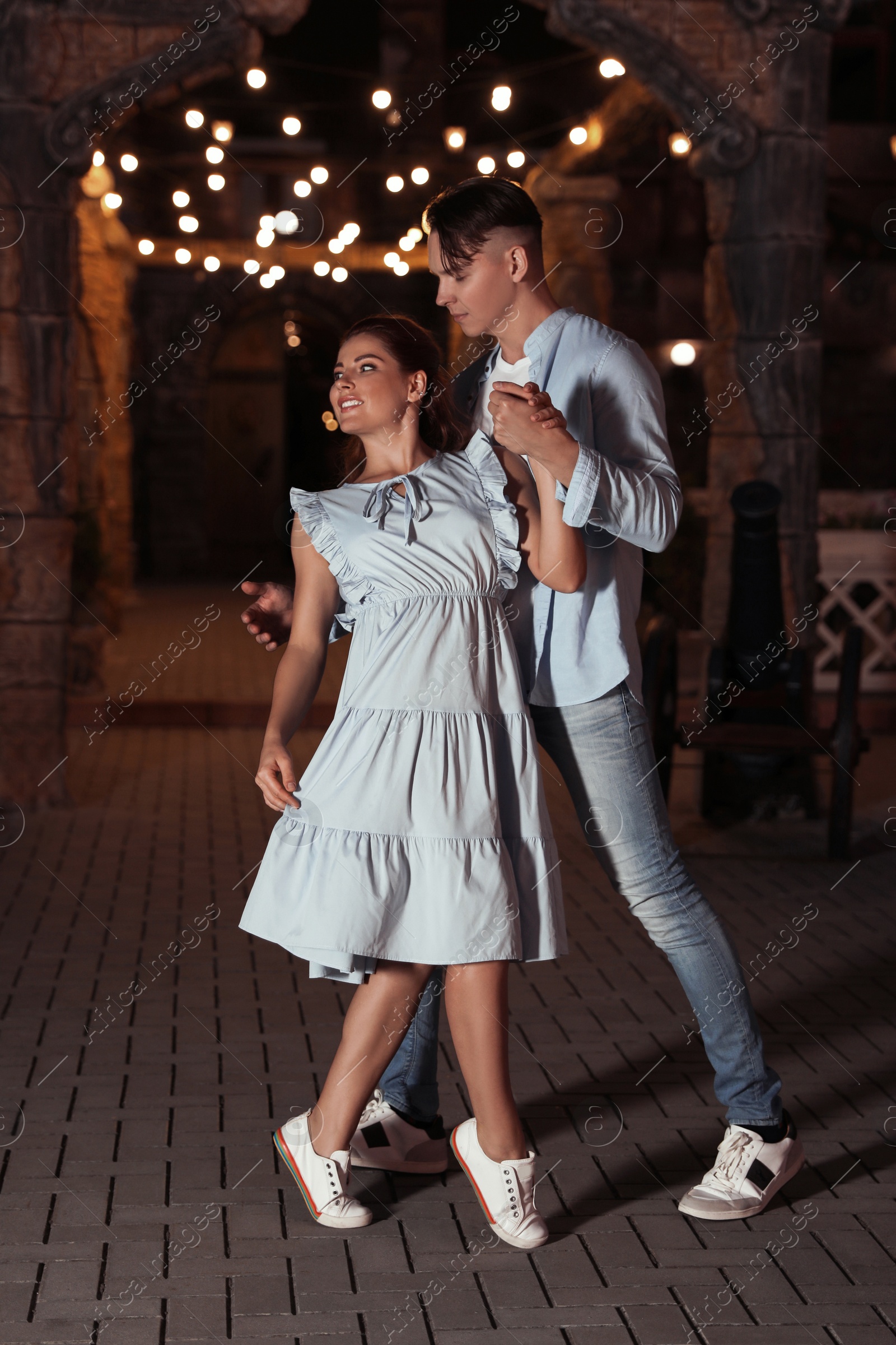 Photo of Beautiful young couple practicing dance moves in evening outdoors