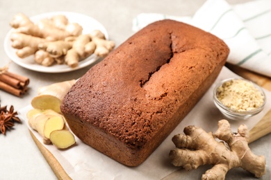 Delicious gingerbread cake and ingredients on light grey table, above view