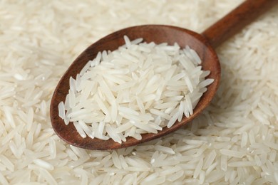 Photo of Raw basmati rice and spoon as background, closeup