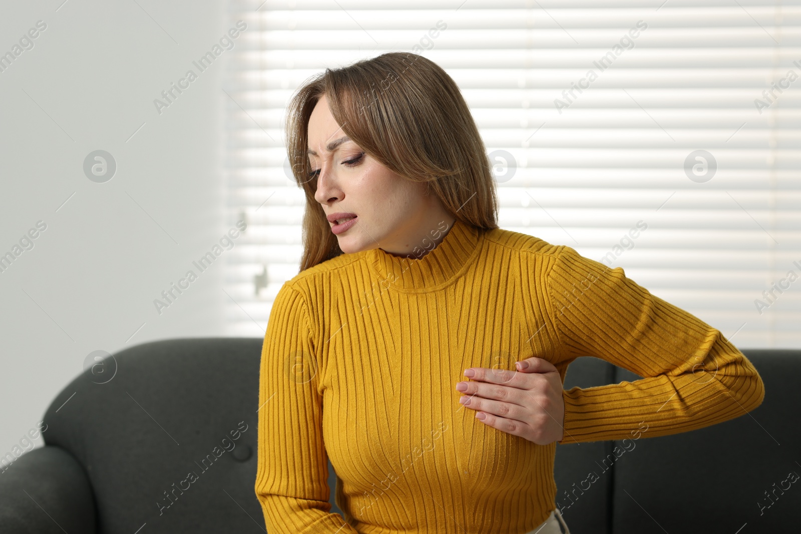 Photo of Mammology. Young woman doing breast self-examination at home