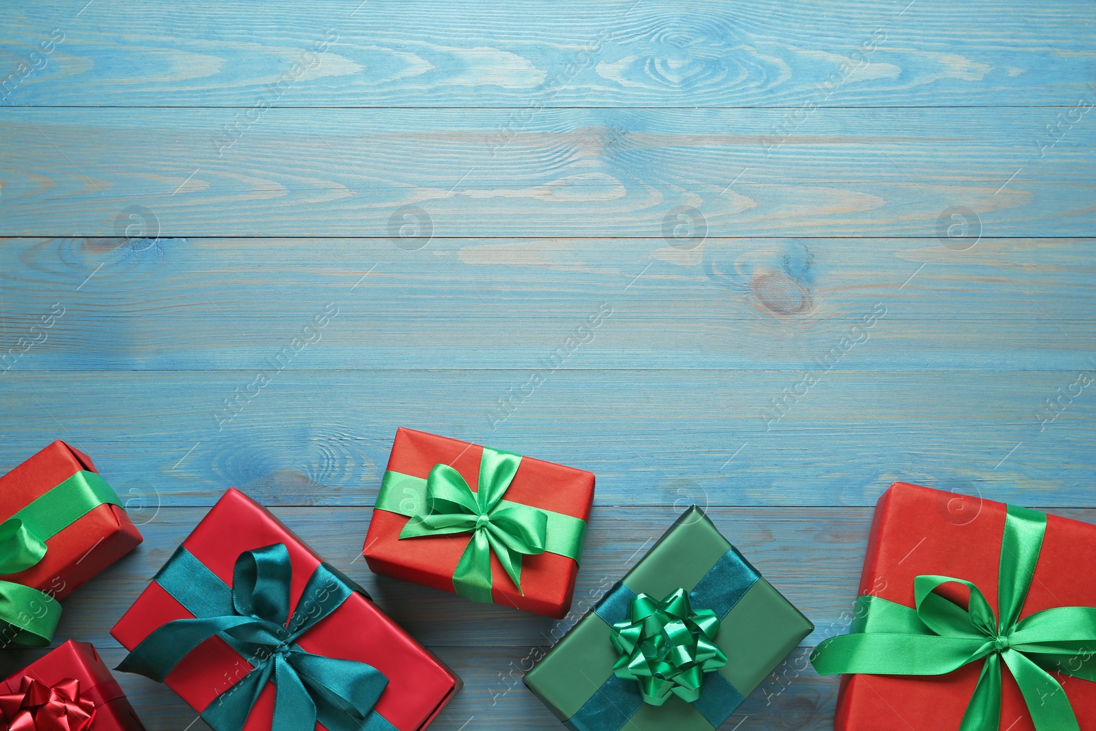 Photo of Many gift boxes on light blue wooden table, flat lay. Space for text