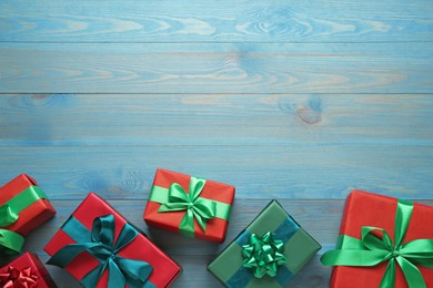 Photo of Many gift boxes on light blue wooden table, flat lay. Space for text