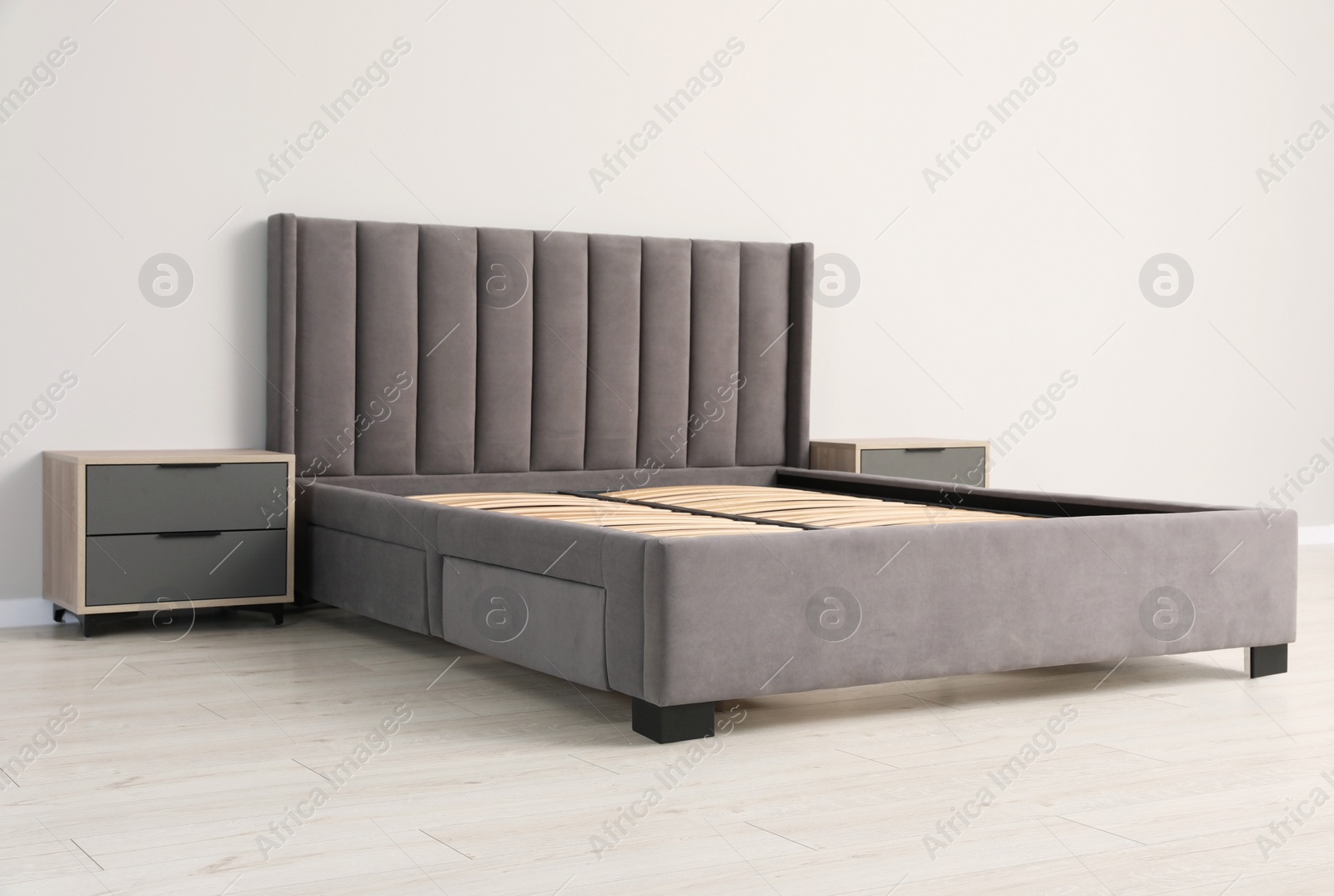 Photo of Comfortable bed with storage space for bedding under slatted base in room