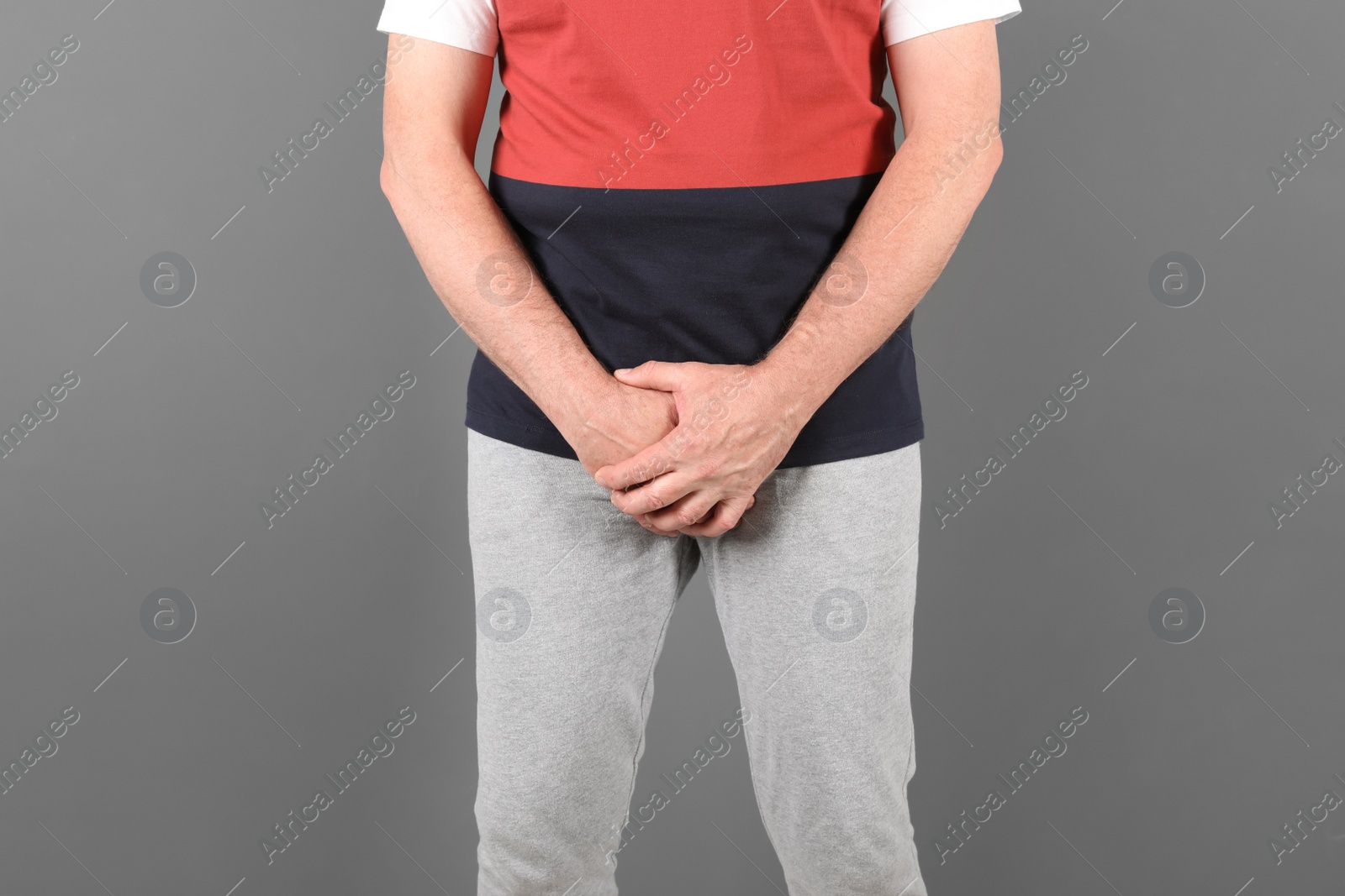 Photo of Mature man with urological problems suffering from pain on grey background