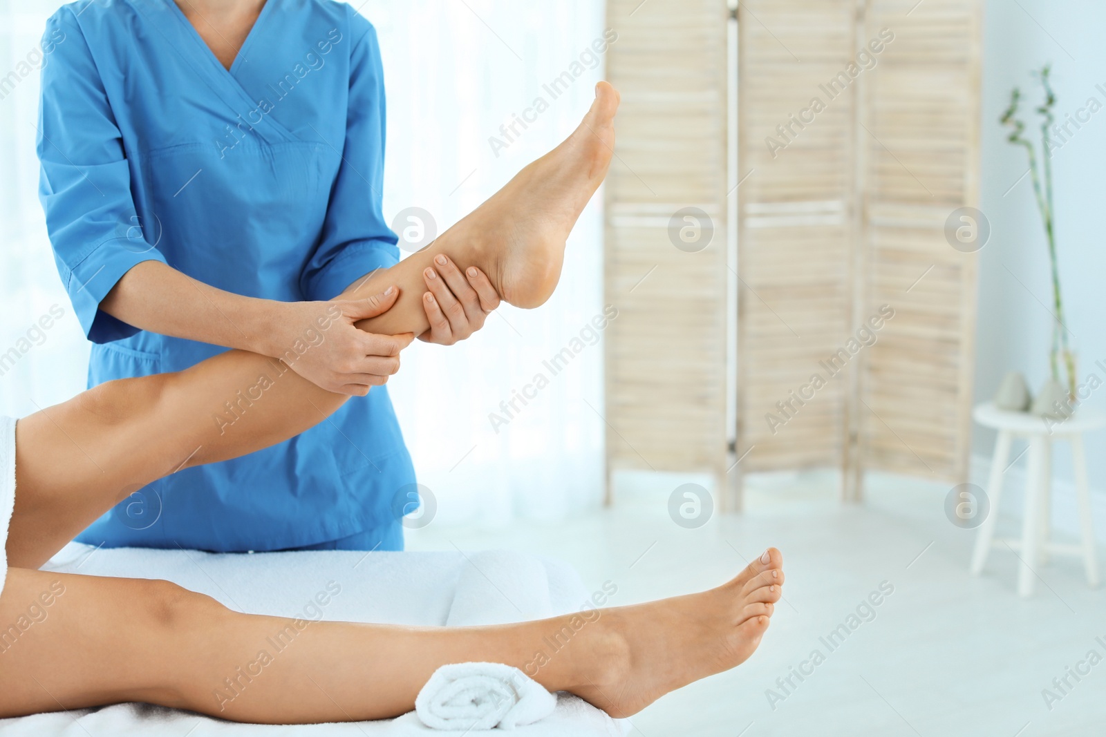 Photo of Woman receiving leg massage in wellness center