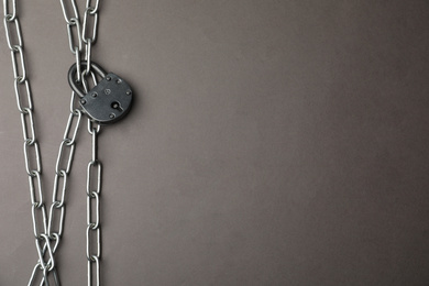 Photo of Steel padlock, chains and space for text on grey background, flat lay. Safety concept