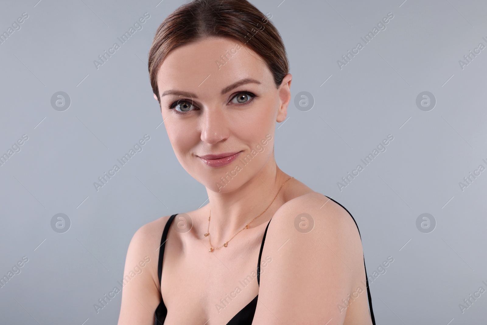 Photo of Beautiful woman with elegant necklace on light grey background